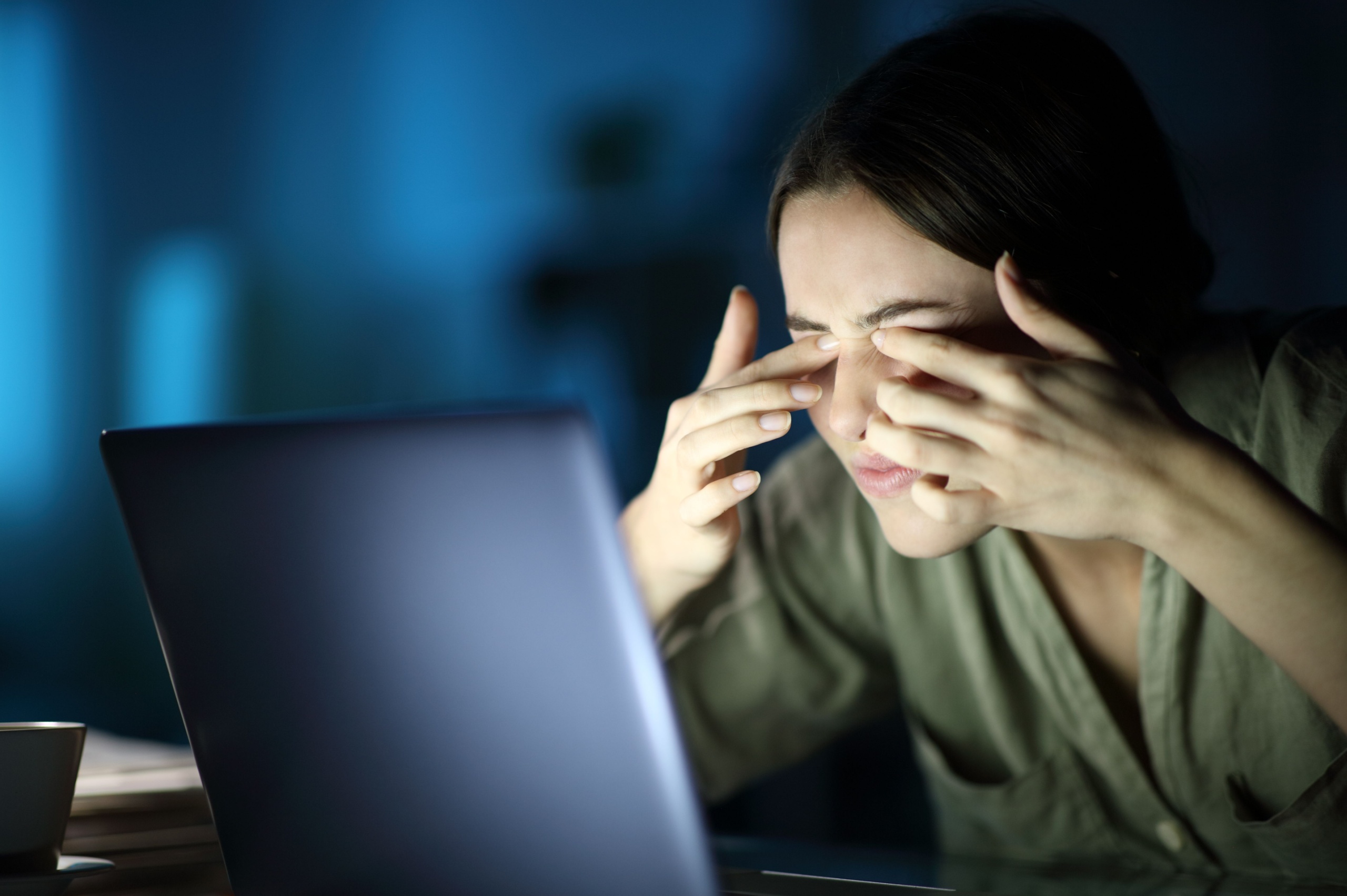 Mujer se frota los ojos frente a la pantalla de un ordenador